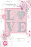 This anniversary card offers a soft, intimate tribute to lasting romance, its design unfolding in pastel pinks, muted mauves, and silvery greys that mirror the gentle light often seen over Swiss Cottage rooftops. At the centre sits the word LOVE, crafted in raised glitter that feels velvety to the touch. The letters are edged just enough to glisten, and the O is replaced with a shimmering, silver-textured heart, embossed so it becomes the emotional focal point of the card. Around this, delicate flowers bloom across the surface in blush and mauve tones, their petals painted with a watercolour softness that suggests both care and lightness. Fine, flowing lines trace stems and tendrils that loop and curl like the graceful arcs of a florist's hand while arranging an anniversary bouquet for delivery near Swiss Cottage station or along Avenue Road. Tiny, playful embellishments - a scatter of petals, swirling accents, and subtle butterflies - add a sense of quiet movement, like a gentle breeze through a spring garden. The phrases On Our Anniversary and I love you today and always are written in an elegant script that curves naturally around the design, giving the impression of heartfelt words whispered between partners. The composition feels balanced and airy, with plenty of soft space so nothing seems crowded or loud. Together, the tactile glitter, romantic colours, and floral details create a card that feels like a keepsake, perfect for marking another shared year with tenderness, gratitude, and love.